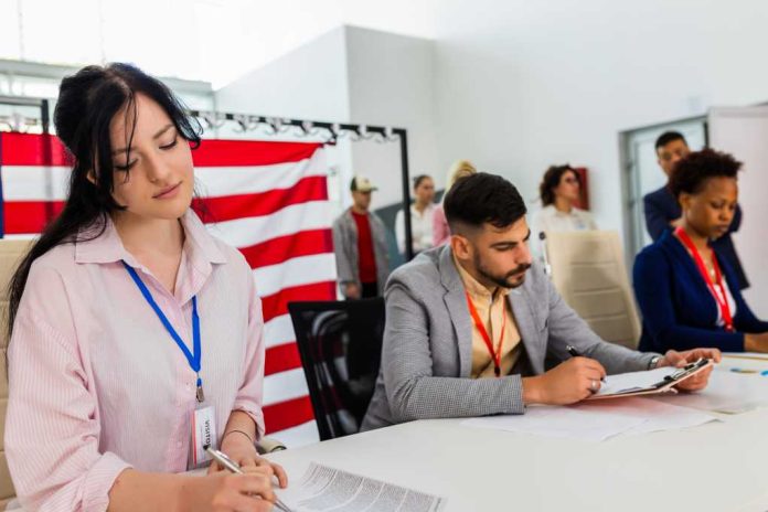 Election-commission_2495850511 People seated at a table filling out forms in a bright office