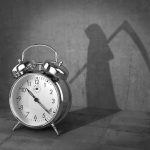 alarm clock with grim reaper shadow