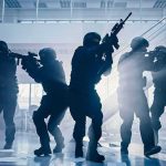 Tactical police team advances through a smoky office building