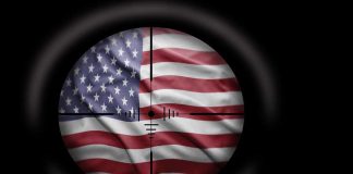JUST IN — Iran Barrage AIMED at US BASES — What Got HIT? View of the American flag through a sniper scope