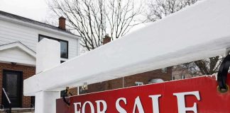For sale sign in front of a house in winter