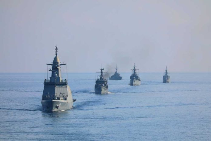 shutterstock_2761560747 A fleet of military ships sailing in the ocean