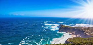 Malibu Mansion MELTDOWN Hits KAMALA Rocky coastal cliffs with turquoise ocean and bright sun