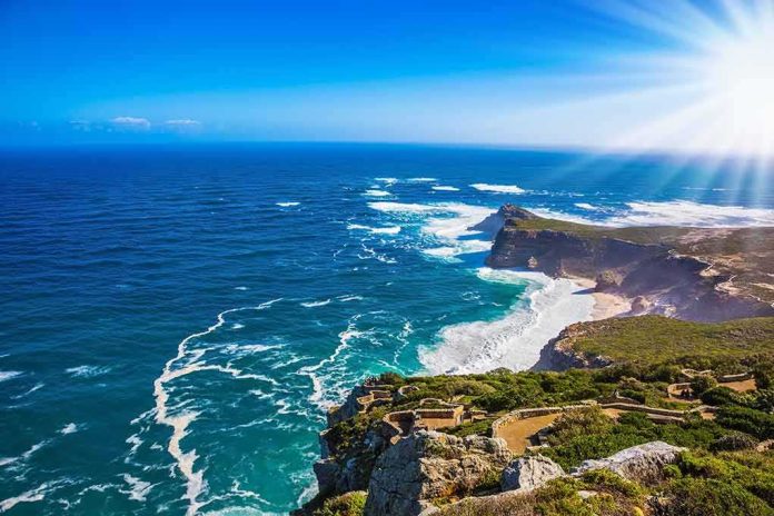 shutterstock_485951866 Rocky coastal cliffs with turquoise ocean and bright sun