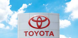Toyota dealership sign with red logo against blue sky