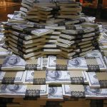Stacks of U.S. hundred-dollar bills arranged in a pyramid