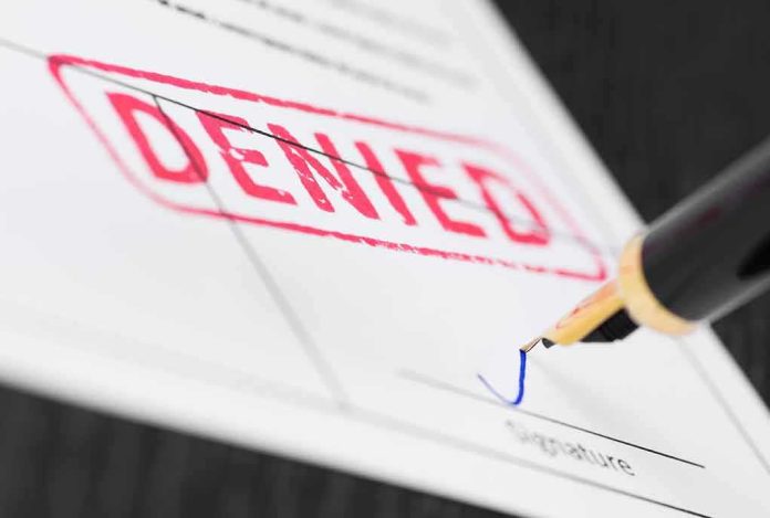 Fountain pen signing a form marked denied