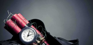 Time bomb with clock and dynamite sticks in a black bag