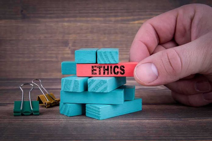 Hand holding a red block labeled ethics above teal blocks