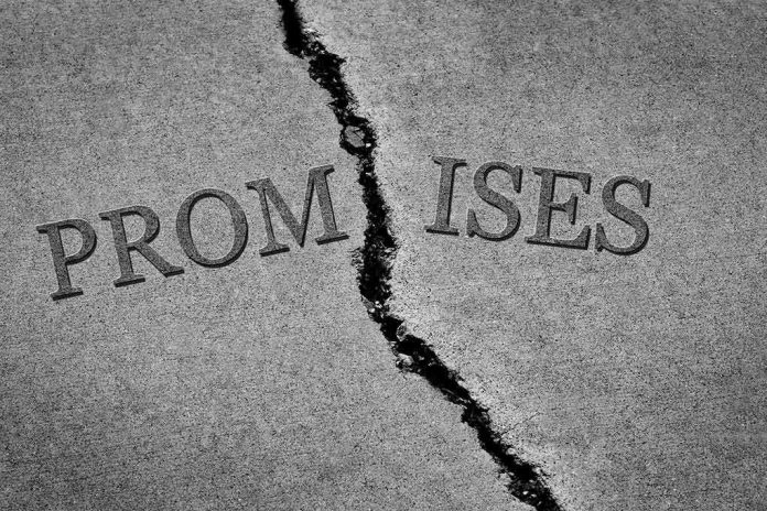 Cracked pavement splitting the word promises