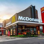 BIZARRE ID Check McDonald’s — NOT KIDDING McDonald's restaurant exterior with drive-thru at sunset