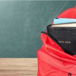 Parent BANNED 1 YEAR Over Classroom DISPUTE Red backpack with books on a classroom desk
