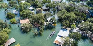 Aerial view of flooded neighborhood with rescue boat navigating streets