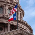 Texas and U.S. flags in front of a capitol building dome