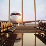 Airplane seen through terminal windows with empty gate seating