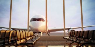 Airplane seen through terminal windows with empty gate seating