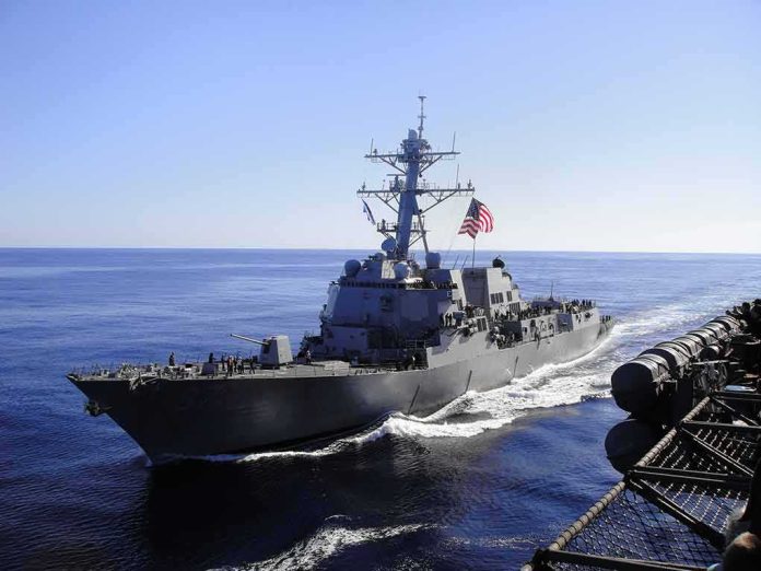 naval destroyer sailing at sea with flag flying