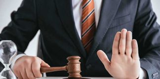 Judge with gavel raising hand in stop gesture