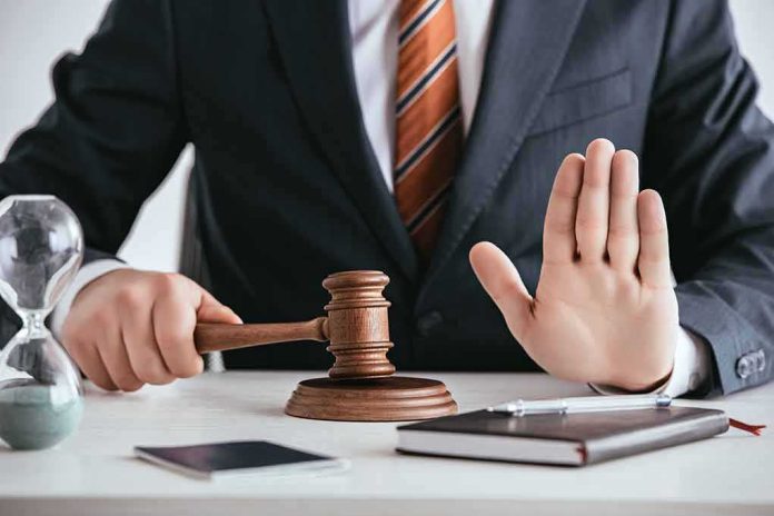 Judge with gavel raising hand in stop gesture
