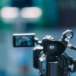 LIVESTREAM — Congregant Bloodied, Guard Headbutted Video camera filming a speaker at a podium