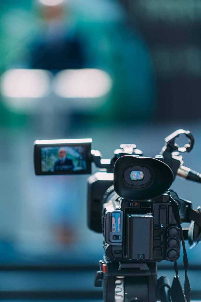 Video camera filming a speaker at a podium
