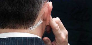 security agent with earpiece touching ear