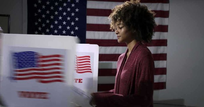 Voter at a polling booth with an American flag backdrop