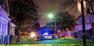 Candidate JAILED After Camera Shootings Police car blocks residential street at night behind caution tape