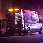 Ambulance at night with paramedics attending a patient