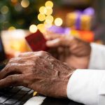 Hands using a laptop and holding a credit card