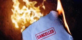 Burning paper stamped cancelled held by hand