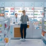 Customer at pharmacy counter speaking with pharmacist