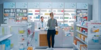 Customer at pharmacy counter speaking with pharmacist