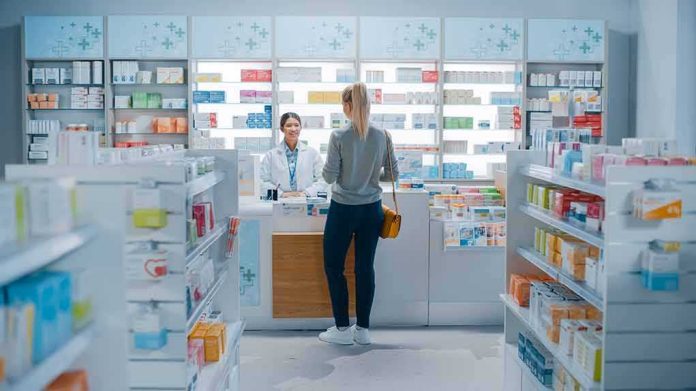 Customer at pharmacy counter speaking with pharmacist