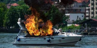 Motorboat on fire near a riverside city