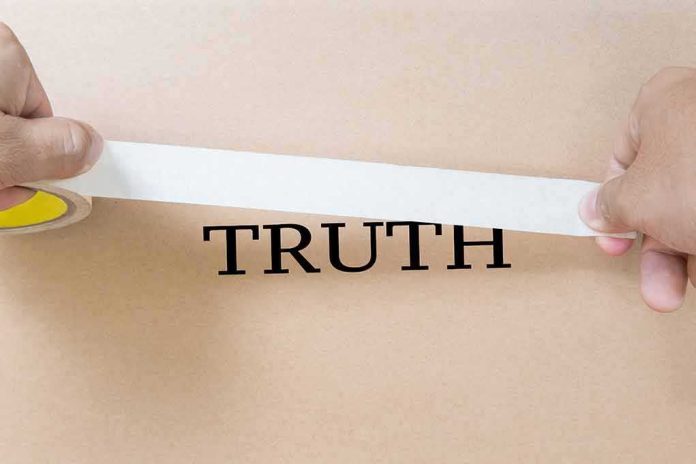 hands placing white tape over the word TRUTH on cardboard