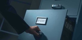 Hand opening a filing cabinet drawer labeled top secret