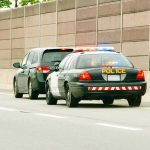Police car with flashing lights stops a minivan on highway