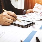 OpenAI’s Scandal: $500M Deal Scrutinized Businessperson analyzing charts with tablet and papers