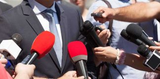 He Put America Below Al-Qaeda — Two 2028 Hopefuls Split Over HIM Person in suit surrounded by microphones during media interview