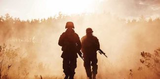 Our Last Troops Just Pulled Out — What We LEFT There Two soldiers walking through a smoky field at sunset
