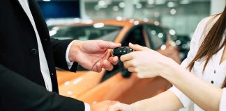 Handshake and car keys changing hands in a showroom