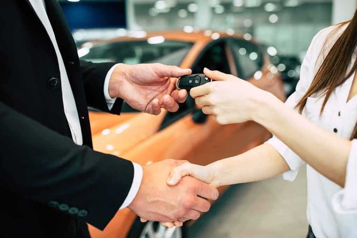 Handshake and car keys changing hands in a showroom