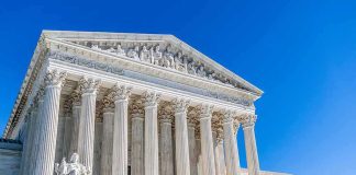 Supreme Court building with tall marble columns under a clear blue sky