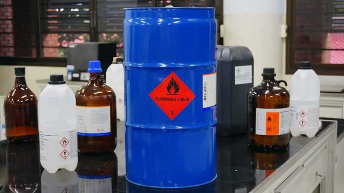 Blue chemical drum with flammable hazard label in a laboratory