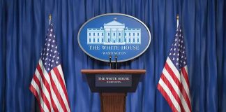White House press podium with microphones and two American flags