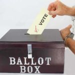 Foreigners Busted Voting For PRESIDENT. They Weren’t The Only ONES Hand in handcuffs casting a vote into a ballot box