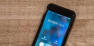 Smartphone on wooden surface showing an incoming robocall screen
