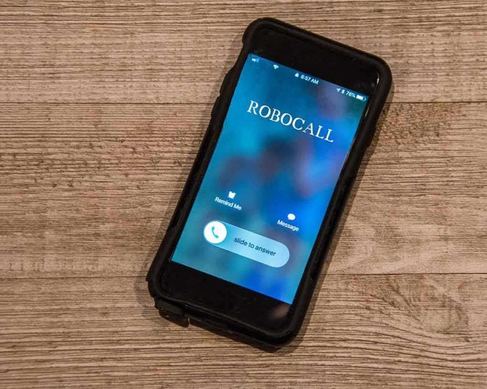 Smartphone on wooden surface showing an incoming robocall screen