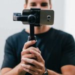 Person holding a smartphone on a handheld gimbal